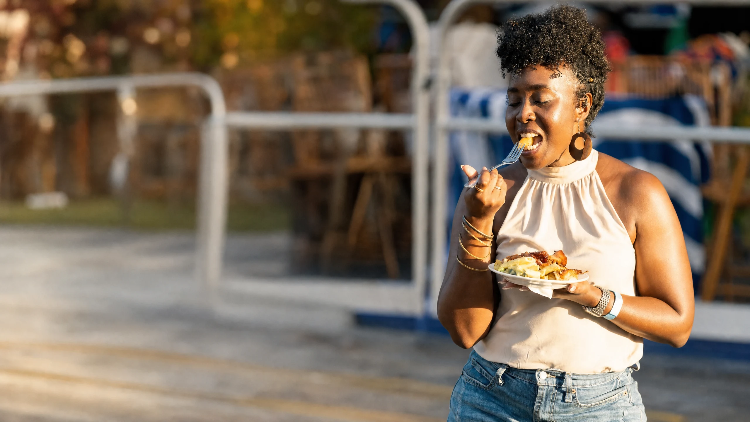 Woman enjoying Caribbean food at an outdoor community festival