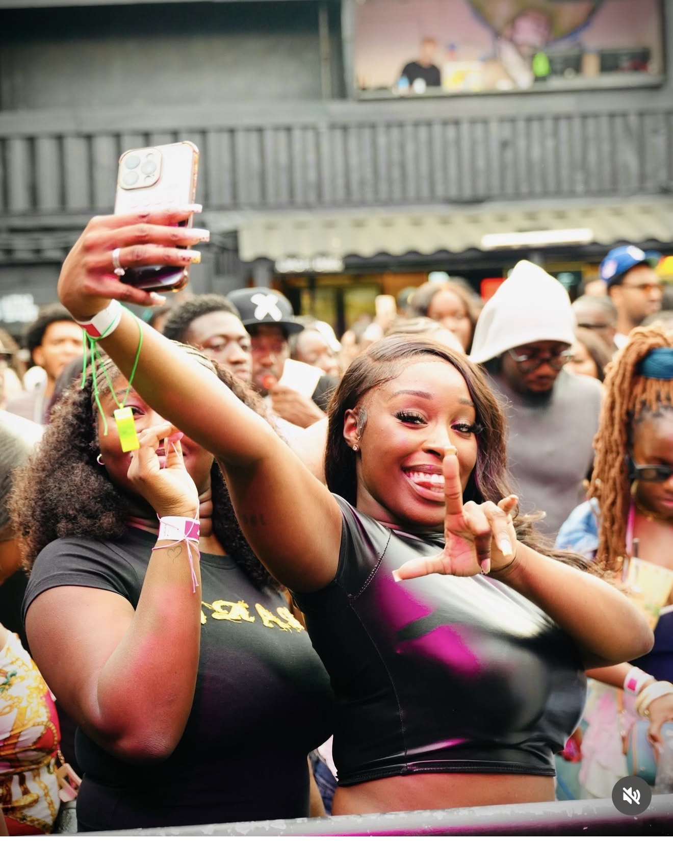 A packed crowd smiling, dancing, and recording the moment.