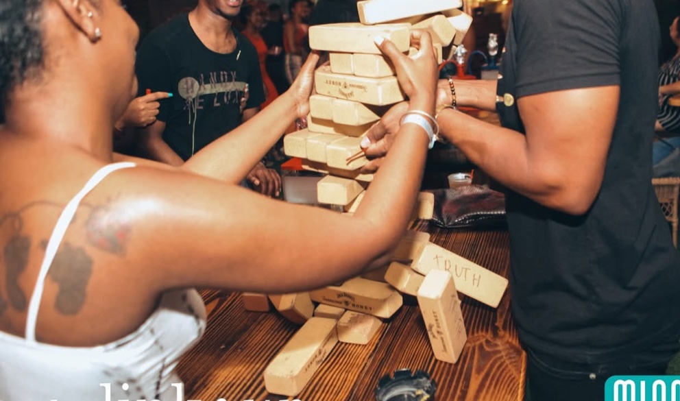 Guests gathered around a table game at a lively outdoor event.
